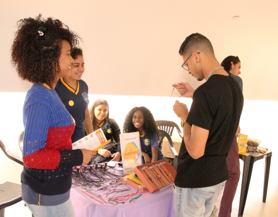 As empreendedoras da X Acessórios, da Escola Estadual Murgy Hibraim Sarah, apresentando seus produtos a um cliente na Cidade Administrativa. Foto: Franciele Xavier (ACS/SEE-MG)